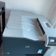 HP Color LaserJet Enterprise M750 모델 사용 중이며, 출력물 상단에 검은색 줄이 생겨서 수리