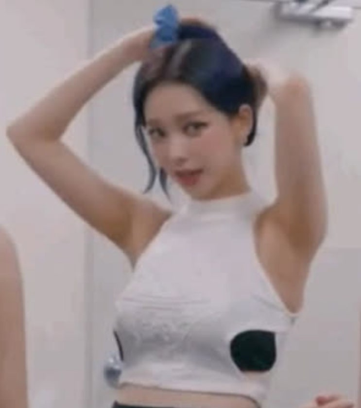 크롭 탑을 입고 양손으로 자연스럽게  머리를 쓸어 올리며 묶는...